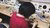 Woman in red t-shirt sitting at repair bench