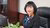 In this photo Duong Kim Anh poses with smile seated at her work desk